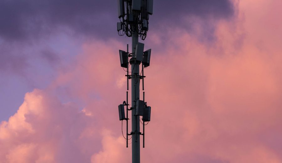 Telecommunications tower against dusk clouds